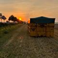Afgedekte container van Transportbedrijf Wit langs een akker bij zonsondergang