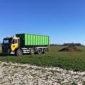 Containerwagen van Transportbedrijf Wit met een groene mestcontainer op het land
